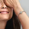 A close-up shot of a woman's arm wearing a Pandora bracelet with a charm. Produktbild-Vorschau