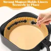 A hand is shown placing a magnetic clip onto the edge of an air fryer liner inside an air fryer basket. Produktbild-Vorschau