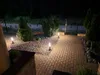 A garden path at night, illuminated by bollard lights, leading to a gate. Produktbild-Vorschau
