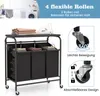 A laundry cart with multiple compartments and an ironing board on top, shown with close-ups of its wheels and features. Produktbild-Vorschau