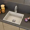 A modern kitchen sink with a beige faucet and a dark countertop. Anteprima dell’immagine prodotto