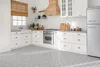 A modern kitchen with white cabinets, a wooden range hood, and a patterned floor. Produktbild-Vorschau