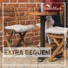 Two wooden chairs with cream cushions are placed around a small round table, with a brick wall in the background. Produktbild-Vorschau