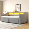 A gray upholstered daybed with built-in storage and LED lighting is shown in a bedroom setting. Voir les images du produit
