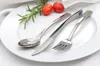 A white plate with a set of silverware, two cherry tomatoes, and a sprig of rosemary. Produktbild-Vorschau