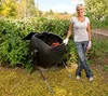 A woman stands next to a black compost tumbler in a garden setting. Náhled obrázku produktu