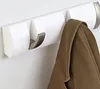 A white wall-mounted coat rack with one hook extended and a brown coat hanging on it. Podgląd zdjęcia produktu