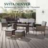 A polyrattan garden furniture set is arranged on a wooden deck, with a blurred background of greenery and a building. Produktbild-Vorschau