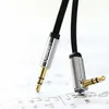 Close-up of two 3.5mm audio cables with metal connectors, one straight and one angled, lying on a sheet of music. Anteprima dell’immagine prodotto