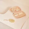 A baby care kit is laid out on a light-colored surface, possibly a changing table or countertop, next to a sink. Produktbild-Vorschau