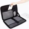 A hand is placing a smartphone into an open laptop bag, which contains a laptop and a mouse. Náhľad obrázku produktu