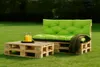Outdoor seating area with a pallet sofa and coffee table on grass. Voir les images du produit