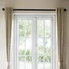 A pair of double doors with white frames and glass panes, covered by beige curtains on a black curtain rod. Produktbild-Vorschau