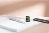 A silver pen, a black SD card, and a black smartphone are placed on a white notebook. Náhled obrázku produktu