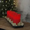 Four red LED candles on a black tray with moss, in front of a decorated Christmas tree. Produktbild-Vorschau