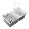 A white double kitchen sink with a silver wire basket and a white faucet, set against a white background. Podgląd zdjęcia produktu