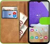 A book-style phone case with a Samsung Galaxy A34 5G phone inside, along with credit cards and euro banknotes. Produktbild-Vorschau