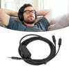 A man wearing headphones and relaxing on a couch, with a product cable shown below. Náhled obrázku produktu