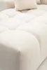 A close-up view of a cream-colored sofa with tufted cushions. Náhled obrázku produktu