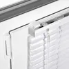 A close-up view of a white aluminum blind attached to a window frame. Produktbild-Vorschau