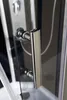 A close-up view of a shower door handle and part of the shower panel. Produktbild-Vorschau