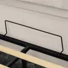 A close-up view of a bed frame with a black metal support and wooden slats, and a beige fabric headboard in the background. Anteprima dell’immagine prodotto