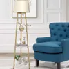 A floor lamp with shelves is placed next to a blue armchair in a room. Podgląd zdjęcia produktu