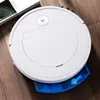 A white robot vacuum cleaner with a blue dustbin is on a wooden floor, next to a book. Náhled obrázku produktu