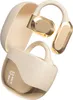 A pair of beige and gold wireless earbuds with their charging case. Náhľad obrázku produktu