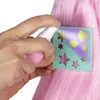 A hand is spraying a stencil with glitter onto pink hair. Podgląd zdjęcia produktu