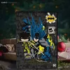 A Batman advent calendar is displayed in a festive setting with wrapped gifts and Christmas decorations. Anteprima dell’immagine prodotto