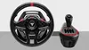 A gaming steering wheel and gear shifter are displayed against a light gray background. Anteprima dell’immagine prodotto