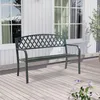 A dark gray metal garden bench with a green patina sits on a light-colored wooden deck in front of a white-paneled house with windows. Produktbild-Vorschau