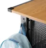 A close-up view of a desk's corner, showing a wooden surface, black metal frame, and a light blue backpack hanging from a hook. Produktbild-Vorschau
