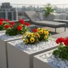 Weiße Kieselsteine als Dekoration in Pflanzkübeln mit bunten Blumen auf einem Balkon Produktbild-Vorschau
