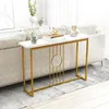 A narrow console table with a marble-look top and gold metal frame is placed in a living room setting, next to a sofa. Náhľad obrázku produktu
