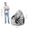 A man stands next to a bean bag chair, with dimensions indicated by lines and text. Voir les images du produit