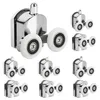 A collection of shower door rollers arranged on a white background. Anteprima dell’immagine prodotto