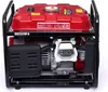 A red and black portable generator is shown from a slightly elevated front-left angle against a white background. Produktbild-Vorschau