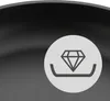 A close-up of a frying pan with a circular graphic overlay showing a diamond and a base. Produktbild-Vorschau