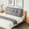 A bed with a large gray wedge pillow behind it, and a gray throw blanket draped over the bed. Produktbild-Vorschau