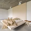 A modern bedroom with a platform bed, wooden headboard, and ceiling lights. Anteprima dell’immagine prodotto