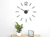 A modern, minimalist wall clock with black hour markers and hands is mounted on a white wall above a small potted plant and a geometric picture frame. Produktbild-Vorschau