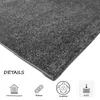 A close-up of a dark gray carpet with icons and text describing its features. Produktbild-Vorschau