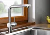 A modern kitchen sink with a chrome faucet and a wooden window sill. Produktbild-Vorschau