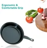 A frying pan is shown next to vegetables and a cutting board with meat. Náhled obrázku produktu