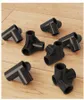 Several black plastic connectors are scattered on a wooden surface. Podgląd zdjęcia produktu