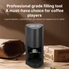 A coffee filling tool is displayed on a wooden surface with some natural elements. Produktbild-Vorschau
