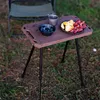 A small portable table set up outdoors on grass, with a bowl of blueberries and a plate of fruit on it. Produktbild-Vorschau