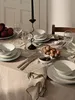A table set for a meal with plates, glasses, cutlery, a candelabra, and food items. Produktbild-Vorschau